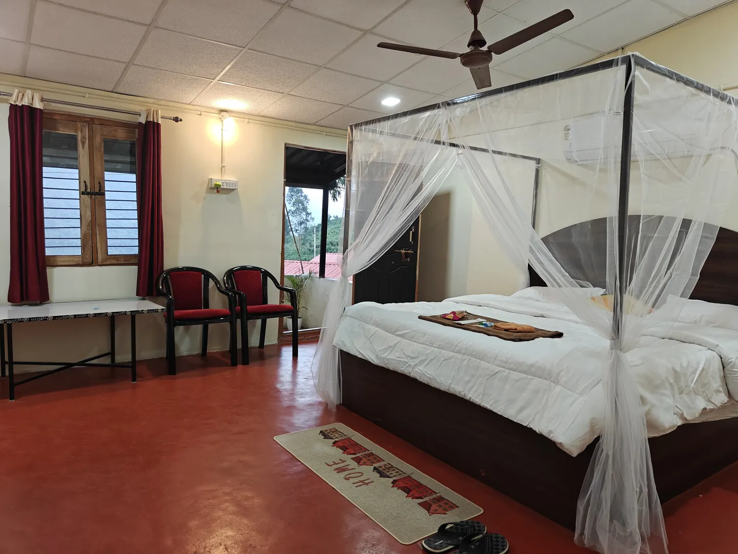 Guest room at Vistara Resort with a four-poster mosquito net